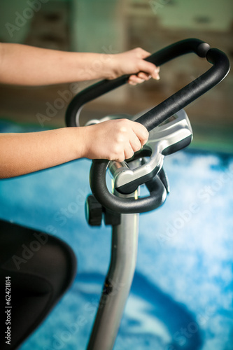 Closeup shot woman riding exercise bike