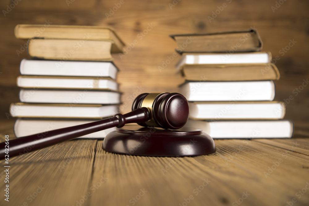 Golden scales of justice, gavel and books wood brown background Golden scales of justice, gavel and books wood brown background