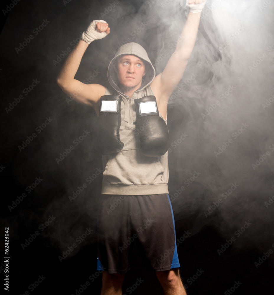 Fototapeta Serious young boxer raising his fists