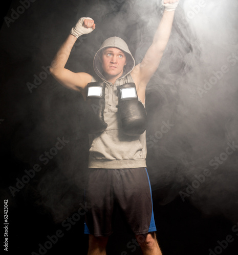 Serious young boxer raising his fists