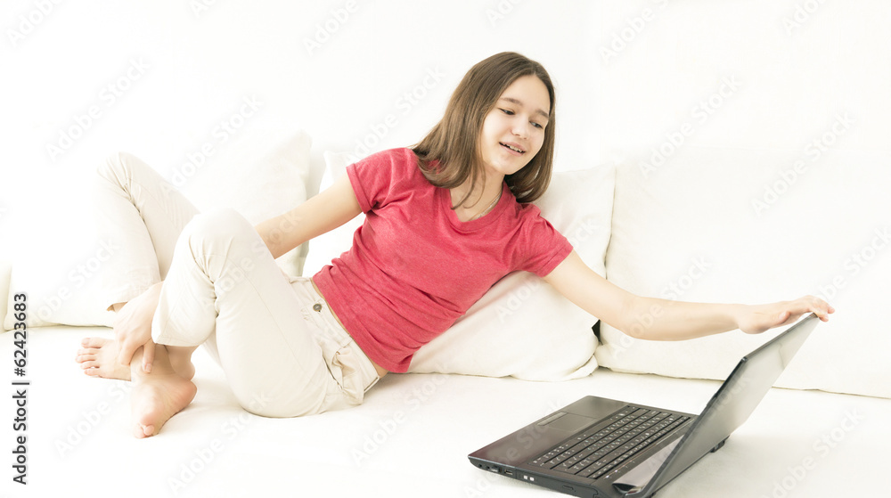 young beautiful girl with a computer on a couch young beautiful girl with a computer on a couch