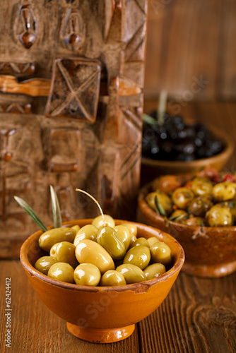 marinated Olives in bowls with moroccan ornament on wood