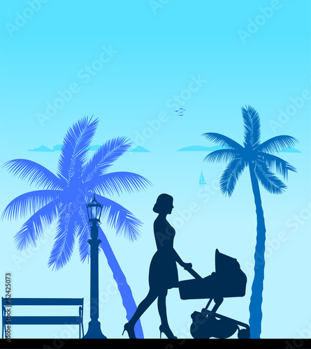 A young mother pushing the stroller and walk the beach