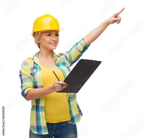 smiling woman in helmet with clipboard photo