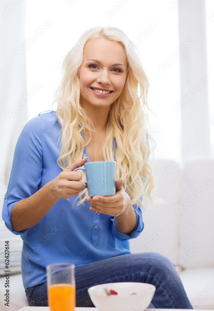 smiling woman with cup of tea having breakfast smiling woman with cup of tea having breakfast