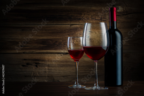 glass and bottle of wine on a wooden background