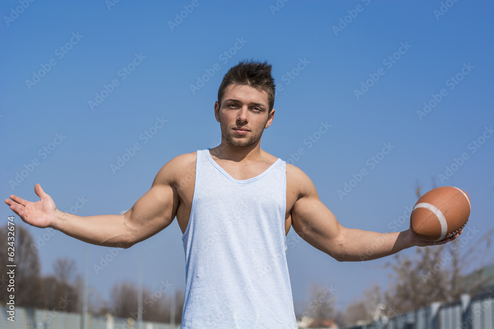 American football player standing with ball in hand outdoors