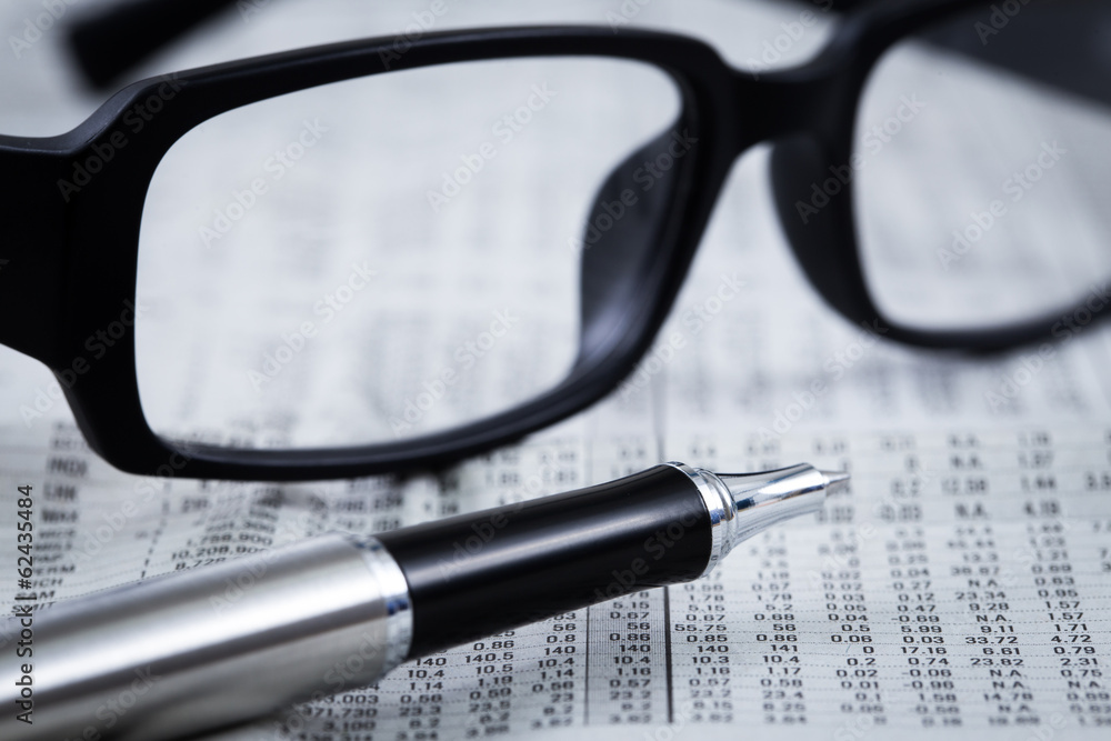 closeup glasses on financial newspaper closeup glasses on financial newspaper