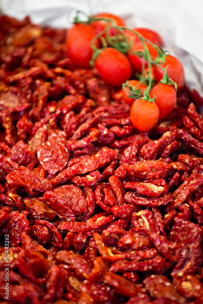 Heap of sundried tomatoes with fresh tomatoes on the vine Heap of sundried tomatoes with fresh tomatoes on the vine