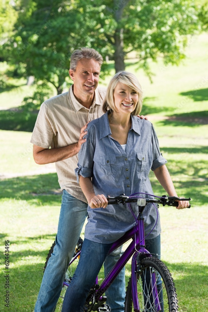 Couple riding bicycle in park Couple riding bicycle in park
