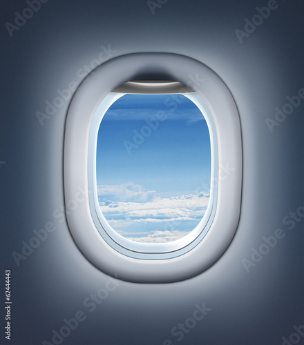 Airplane interior or jet window with clouds and sky.