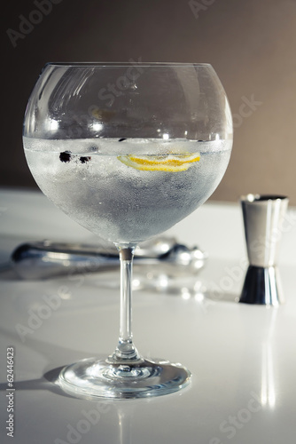 Gin tonic cocktail over a club bar background