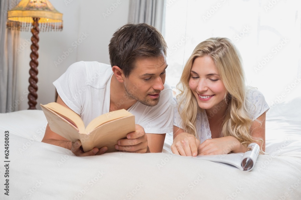 Relaxed casual couple reading books in bed Relaxed casual couple reading books in bed