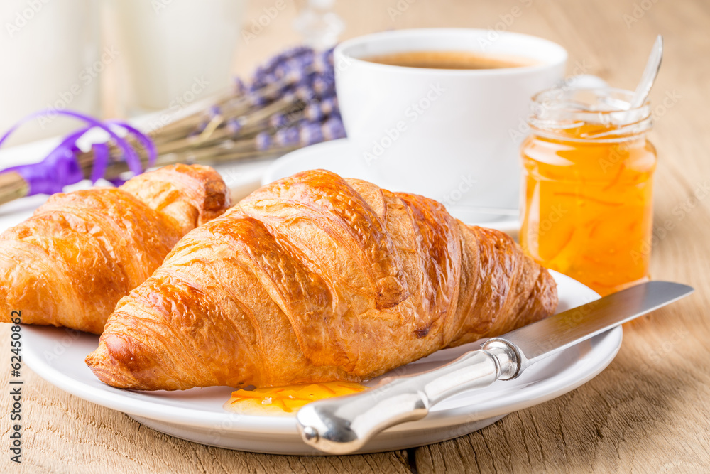 Croissants with orange jam and coffee. Shallow depth of field.