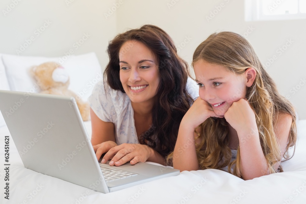 Mother and daughter using laptop in bed Mother and daughter using laptop in bed