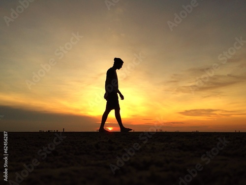  man silhouette walking on the beach