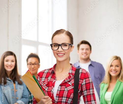 female student in eyeglasses with bag and folders