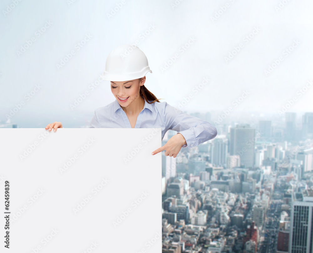 businesswoman in helmet pointing finger to board businesswoman in helmet pointing finger to board