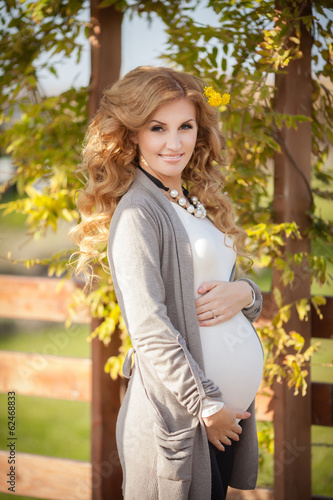 Beautiful pregnant woman with spring flowers outdoor