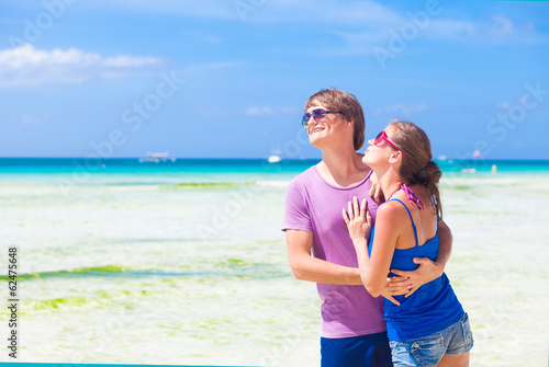 couple in bright clothes hugging on tropical beach in Tulum