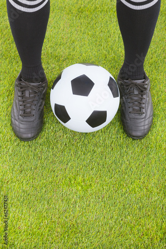 Soccer player's feet  and football on field © Tom Wang