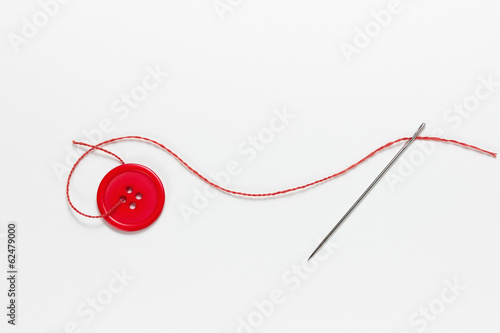 Canvastavla A threaded needle and red button