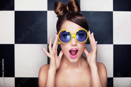 Attractive surprised young woman wearing sunglasses