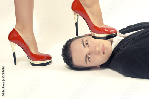 Foto Woman in control of a man, sexy woman' foot on a man' face
