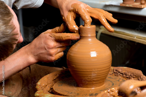 hands of a potter, creating an earthen jar