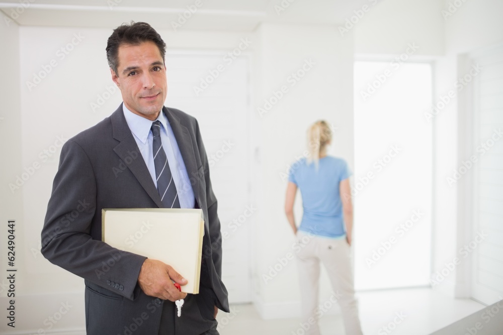 Well dressed real estate agent with blurred woman in background Well dressed real estate agent with blurred woman in background