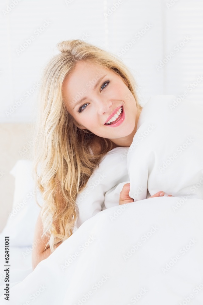 Pretty young woman covering herself with duvet Pretty young woman covering herself with duvet