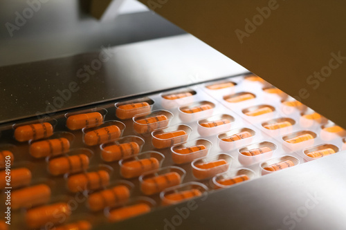 Orange capsules packed in tablet packing machine