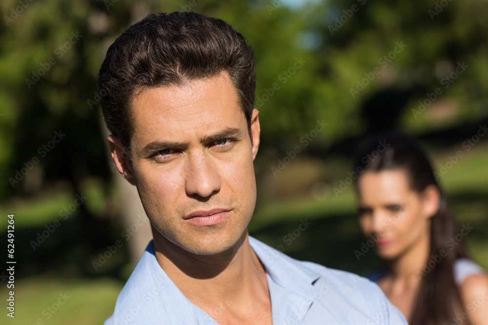 Man with blurred woman in background outdoors Man with blurred woman in background outdoors