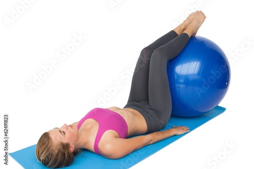Full length of a fit woman exercising with fitness ball