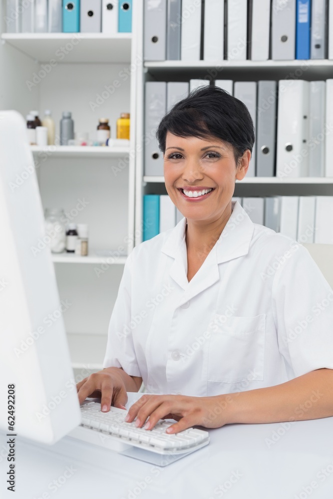 Confident smiling female doctor using computer Confident smiling female doctor using computer