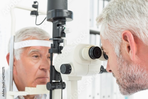 Fototapeta Naklejka Na Ścianę i Meble -  Optometrist doing sight testing for senior patient