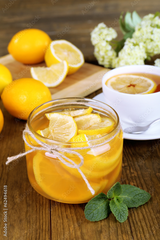 Tasty lemon jam with cup of tea on table close-up Tasty lemon jam with cup of tea on table close-up