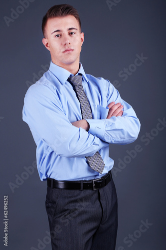 Handsome young man on gray background © Africa Studio