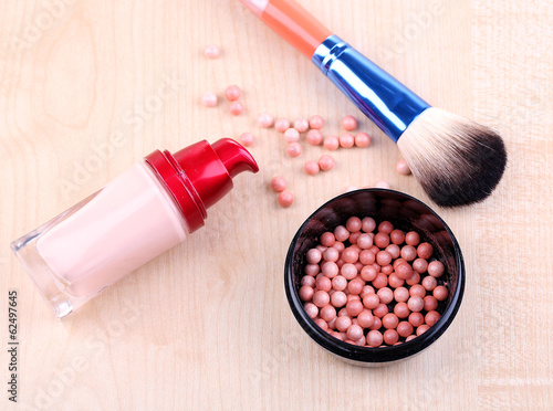 Composition with concealer, powder balls and brush