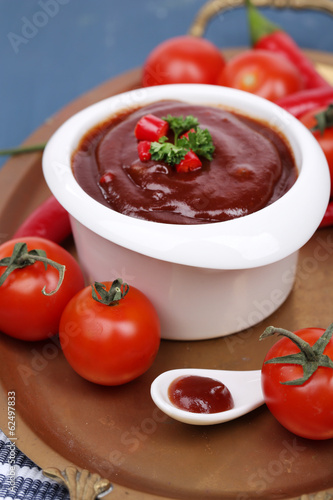 Tomato sauce in bowl on wooden table close-up