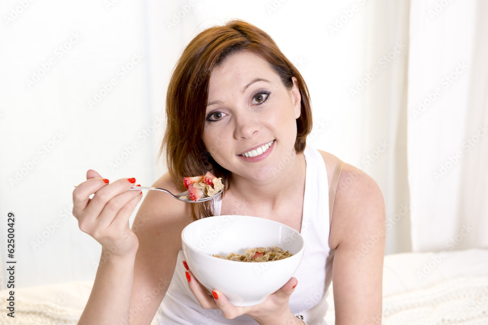 red haired happy woman eatting cereal and stawberries red haired happy woman eatting cereal and stawberries