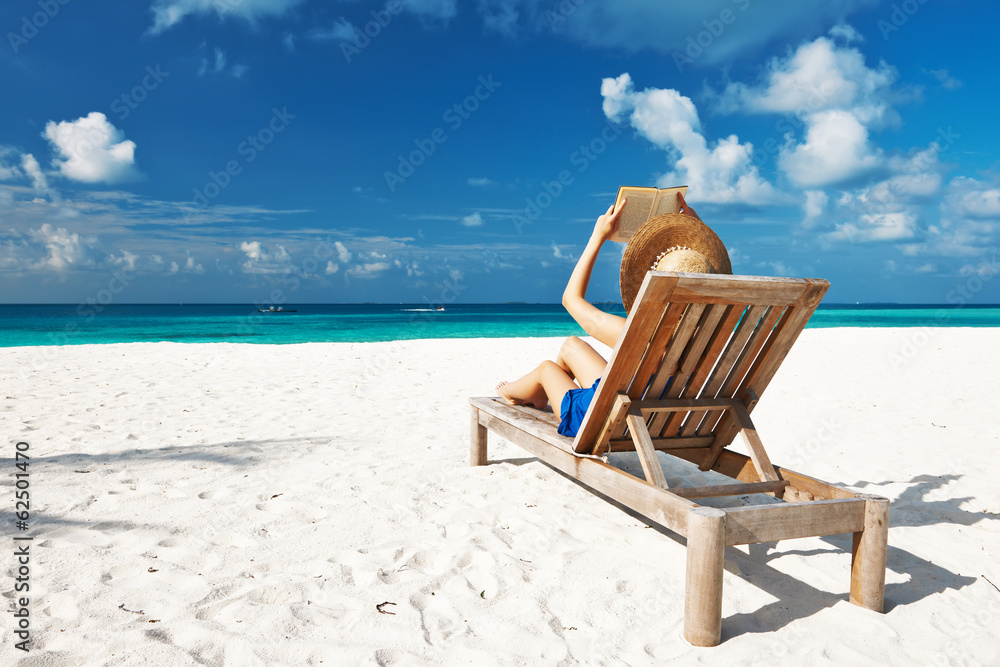 Young woman reading a book at beach