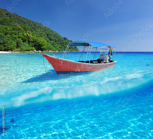 Beach and motor boat with white sand bottom underwater view