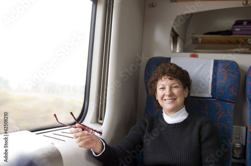 happy female retired middle age senior on first class train in P