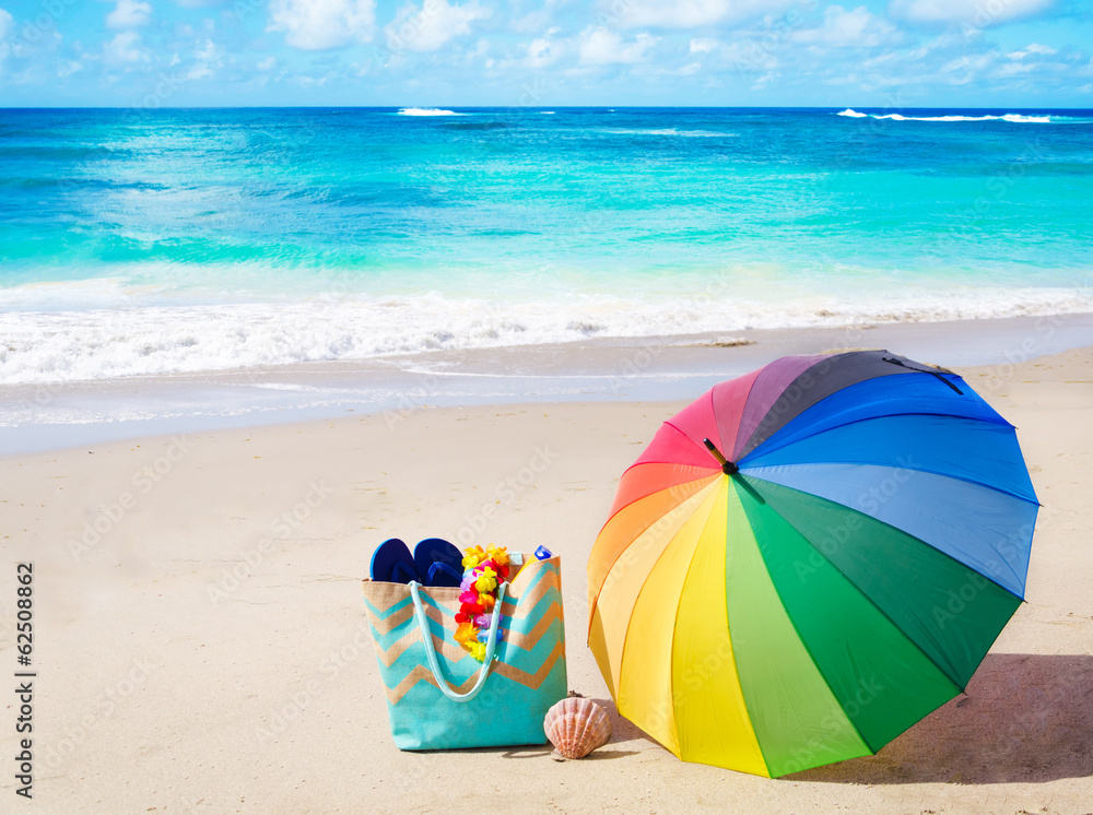 Fototapeta premium Summer background with rainbow umbrella and beach bag