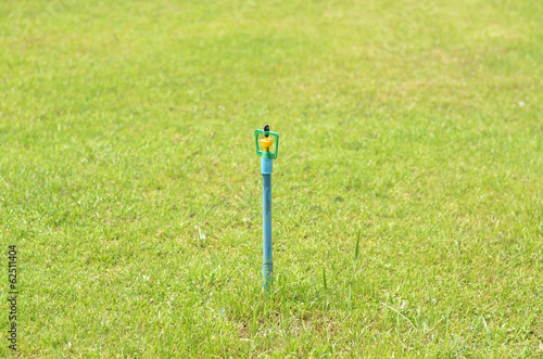 High Close up of lawn sprinkler with green grass