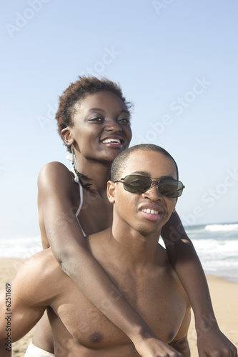 Black couple hold each other on beach