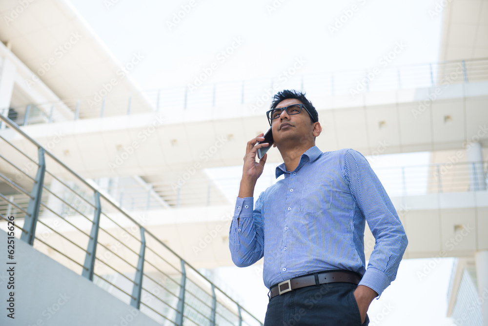 young indian business male in formal with a phone young indian business male in formal with a phone
