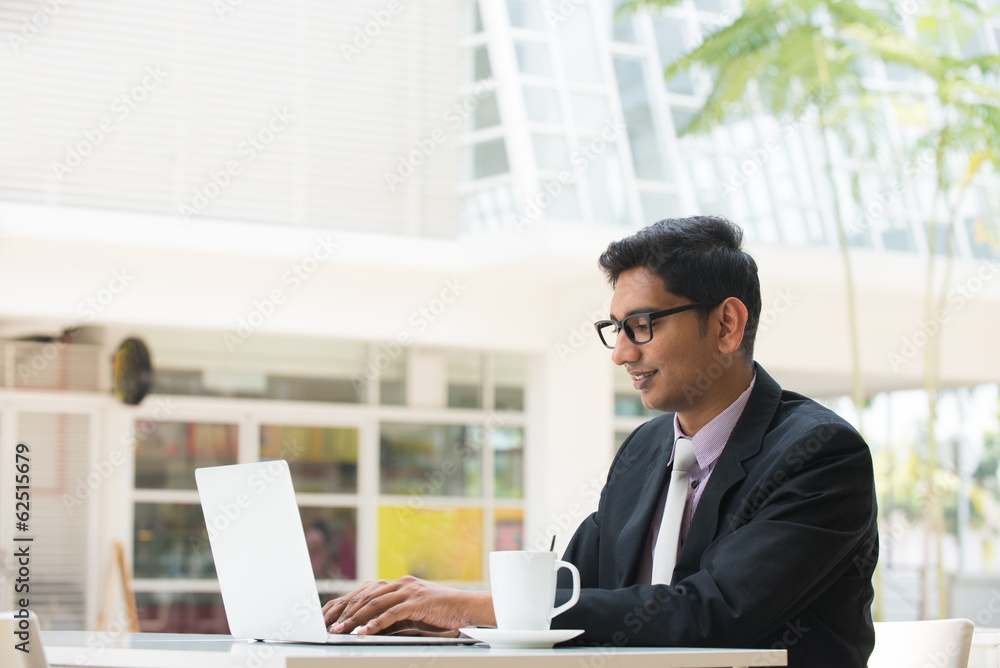 young indian business man on laptop and coffee