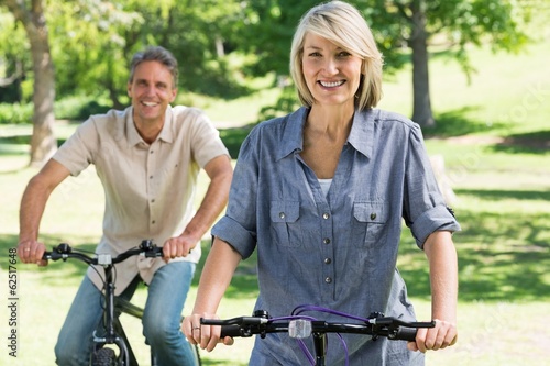 Couple riding bicycles in park